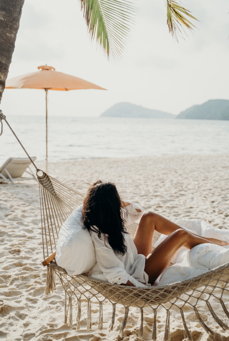 Image of a woman in a hammock on the beach.