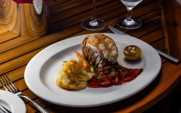 Image of Lobster tail dinner on table with Champagne and Red Roses