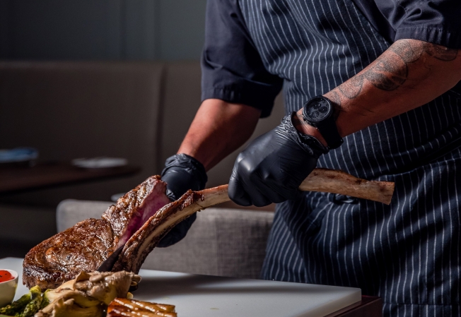 Picture of Chef cutting Tomahawk Steak table side