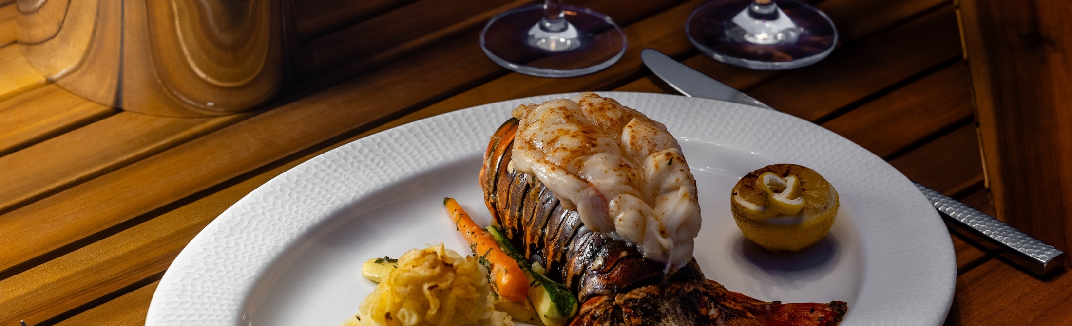 Image of Lobster tail dinner on table with Champagne and Red Roses hero image